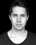 black and white headshot of young Caucasian man with intense eyes. James Simpson.